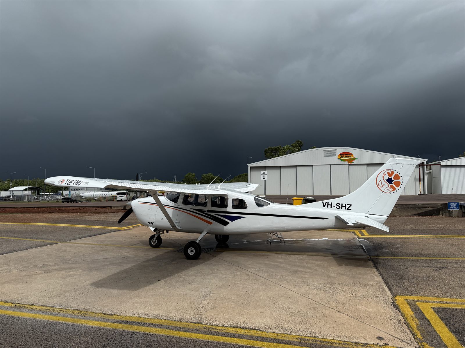 Top End Civil branded Cessna VH-SHZ on the tarmac at the aviation hangar